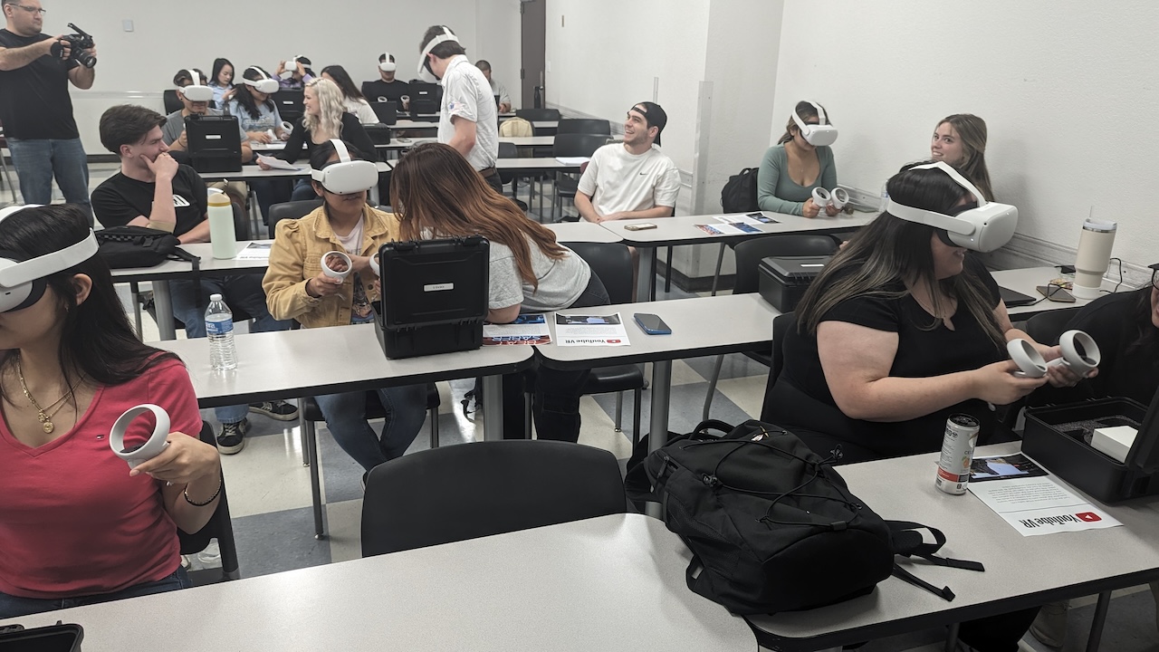 Students seated in a classroom trying out VR headsets