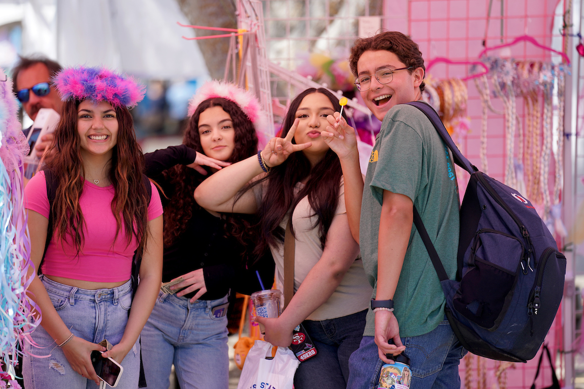 Group of students pose together in a pink decorated booth