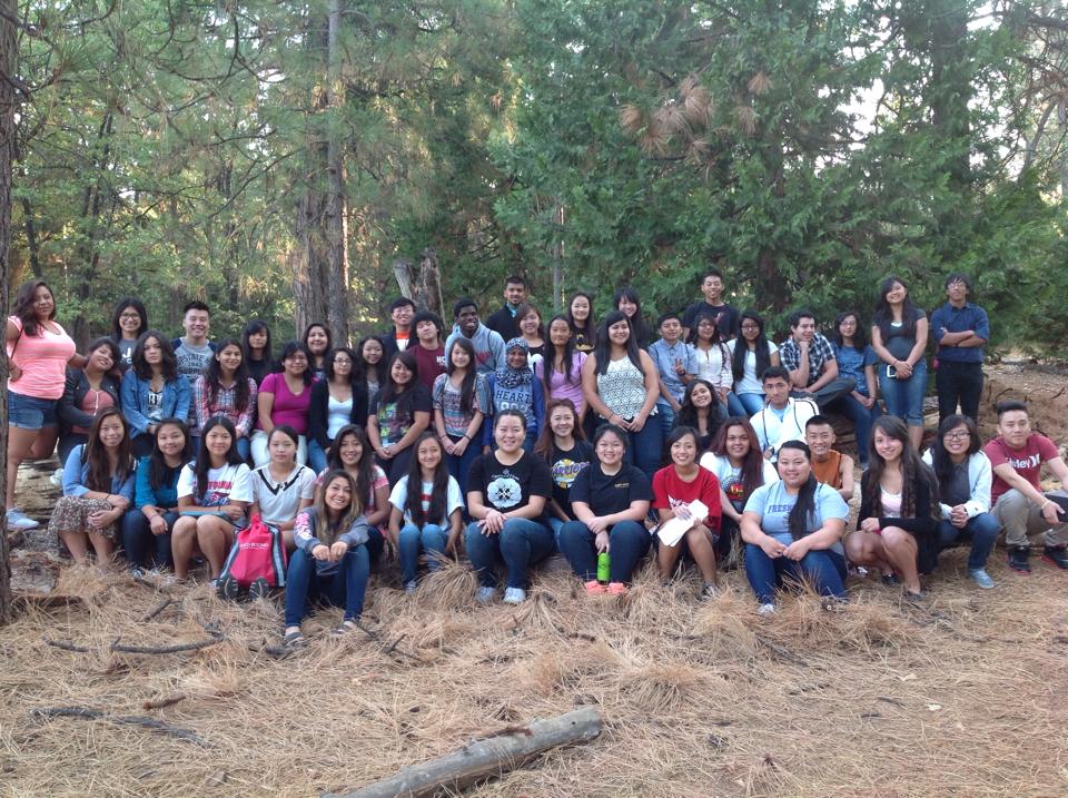 Students Sitting For A group Picture in the Forest